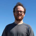 Peter smiling against a blue background